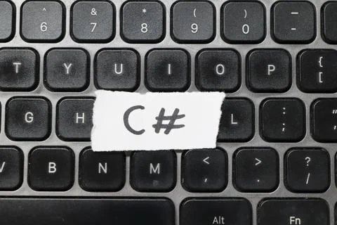 Handwritten note on white paper displayed on a laptop keyboard, showing the Stock-Fotos