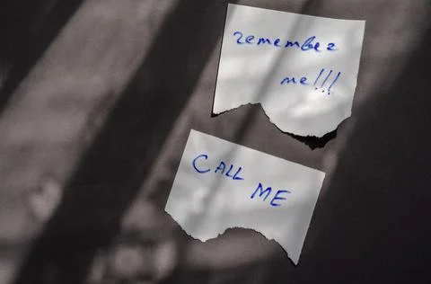 Handwritten notes Call Me and Remember Me on a white pieces of paper. Stock Photos