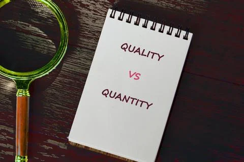 Handwritten quality over quantity message on a spiral pad, on wood, by a vint Stock Photos