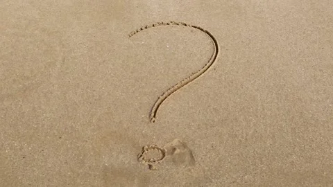Handwritten question mark on a sandy sea beach is wiped by the sea wave Video stock 153813229