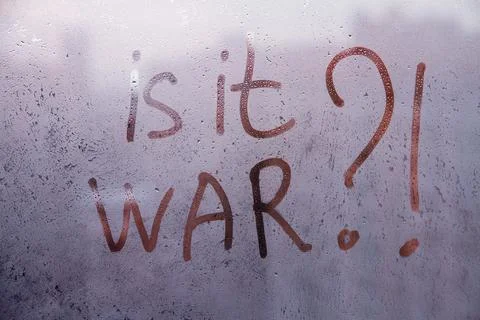 Handwritten red lettering Question Is it war are drawn on misted dark violet  Stock Photos