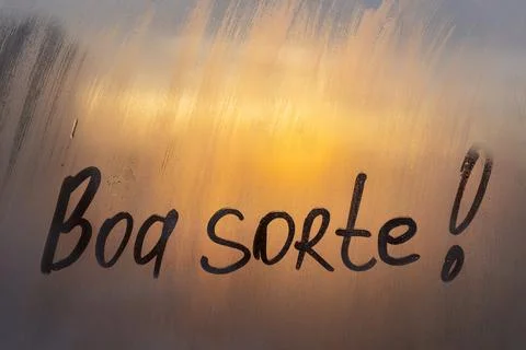 Handwritten Spanish message Boa sorte is Good luck on misted glass on sunset  Stock Photos