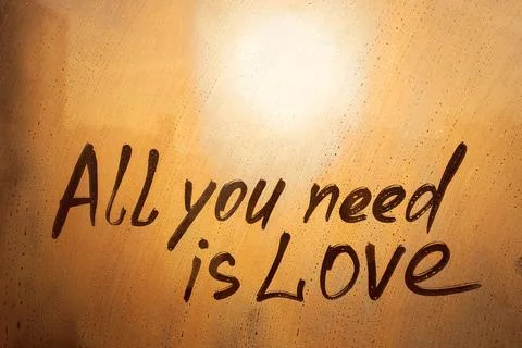 Handwritten text All you need is Love written finger on orange sunset wet w.. Stock Photos