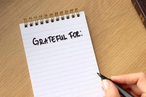 Handwritten text "Grateful for" in a notebook with holy bible Stock-Fotos