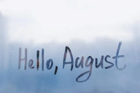 Handwritten text Hello August on wet blue window Stock Photos