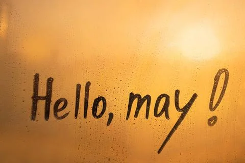 Handwritten text Hello may on wet orange window Stock Photos