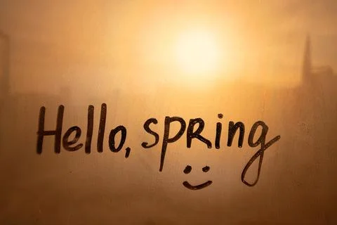 Handwritten text Hello spring and smile on wet orange window Stock Photos