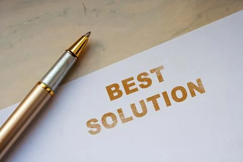 Handwritten text reading BEST SOLUTION on a clean white sheet of paper beside a Foto stock
