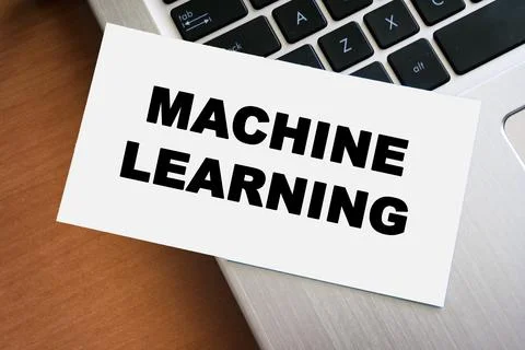Handwritten text reading MACHINE LEARNING on a white card, placed on a laptop Stock Photos