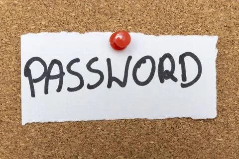 Handwritten text reading PASSWORD attached to a corkboard with a red pushpin. Stock Photos