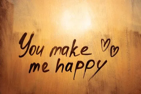 Handwritten text You make me happy written finger with two hearts shape on .. Stock Photos