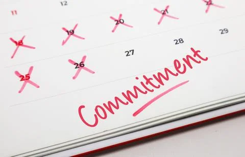 Handwritten word Commitment in red ink on a paper calendar with several dat.. Stock Photos