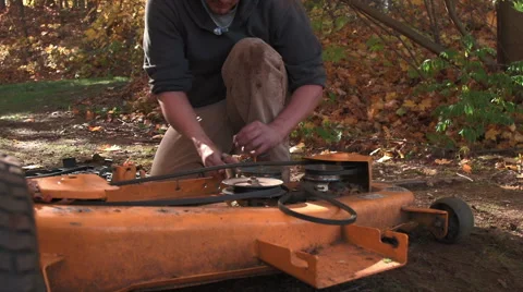 Handyman analyzing issue with spring and gears of tractor Stock Footage 44778186