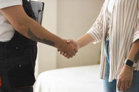 Handyman and client shaking hands, finalizing renovation project agreement,.. Stock Photos