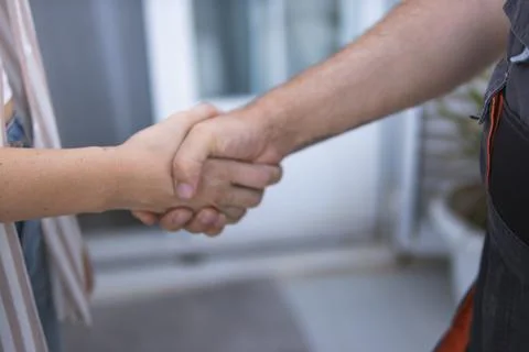 Handyman and client shaking hands, finalizing agreement for home repair ser.. Stock Photos