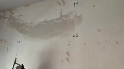 Handyman applying fresh plaster on an old wall for repair Видео 341362959