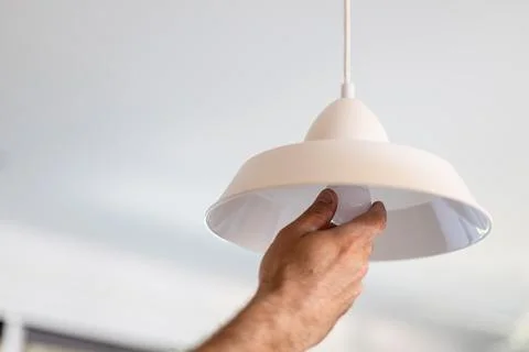 Handyman changing light bulb in home ceiling lamp Stock Photos