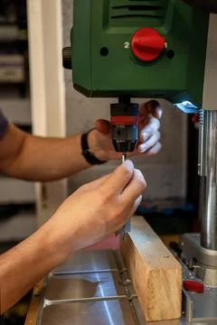Handyman checking up a drill press. Stock Photos