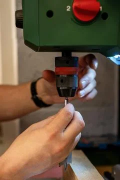 Handyman checking up a drill press. Stock Photos