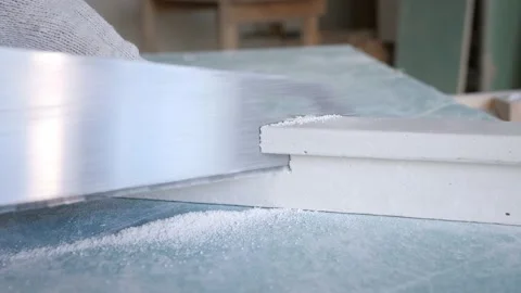 Handyman cuts decorative cornice plaster fretwork on table Stock Footage 151784496