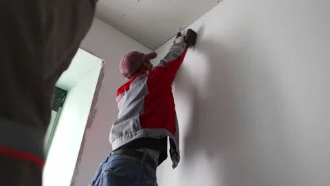 Handyman fastens ceiling panel with electric screwdriver Stock Footage 274069125