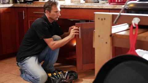 Handyman fixing cabinet with screwdriver in kitchen Stock Footage 71837202