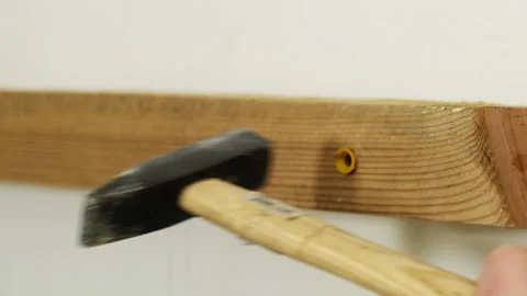 Handyman inserts plastic wall anchor using hammer closeup Stock Footage 304404245