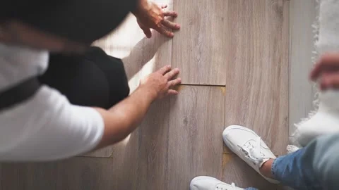 Handyman inspecting damaged laminate flooring in bedroom with female homeow.. Stock Footage 345724735