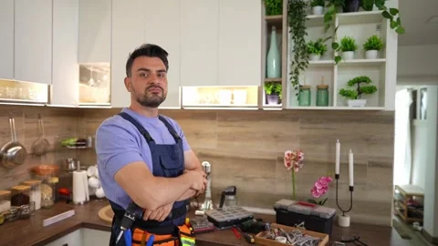 Handyman installing kitchen cabinets and smiling at camera 스톡 동영상 316483214