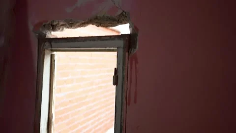 Handyman installing a new window frame on a pink wall 库存影片 347640737