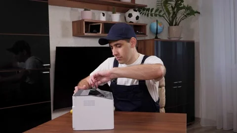 A handyman in overalls with a screwdriver repairs the printer in the office. 動画素材 238903962