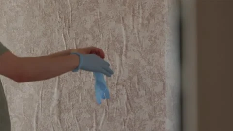 Handyman putting on protective rubber gloves for flood cleaning Stock Footage 338003271