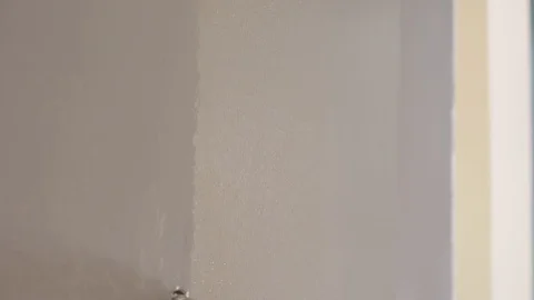 Handyman runs roller brush with handle on new flat wall Video stock 124892603