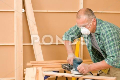 Handyman sanding wooden board diy home renovation Stock Photos