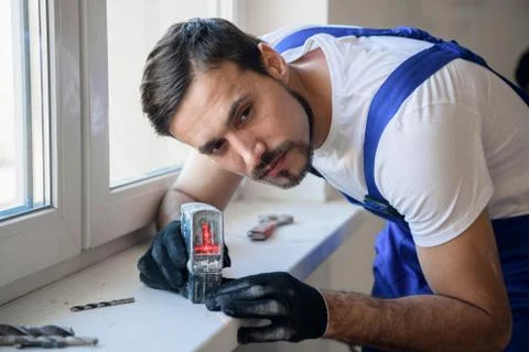 The handyman uses the level on the windowsill Stock Photos