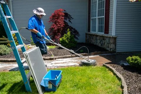 Handyman using a circular power washer to clean a brick walkway in front of.. Stock Photos