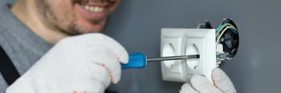 Handyman using screwdriver to install sockets 스톡 사진