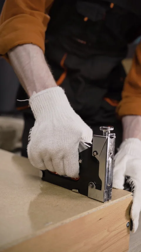 Handyman using stapler to assemble furniture Stock Footage 310035285