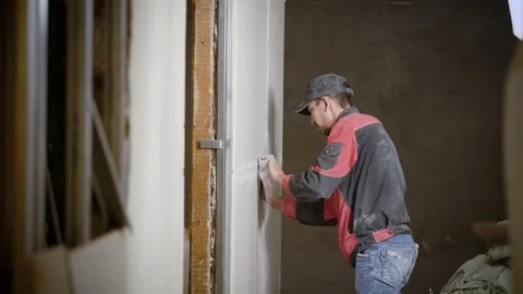 Handyman working on decorating interior wall applying stucco Stock Footage 82991026