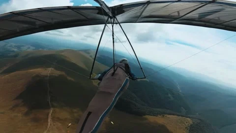 Hang glider circles under the clouds high in the mountains Stock Footage 139750858