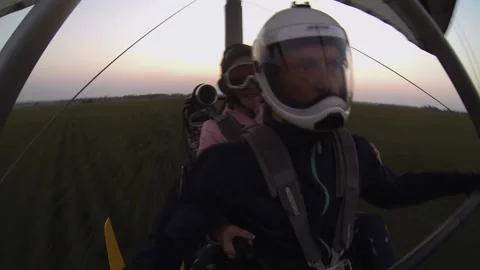 A hang glider flies low over a cornfield at sunset Stock Footage 196242253