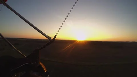 Hang glider flight over cornfield at sunset Stock Footage 197406300