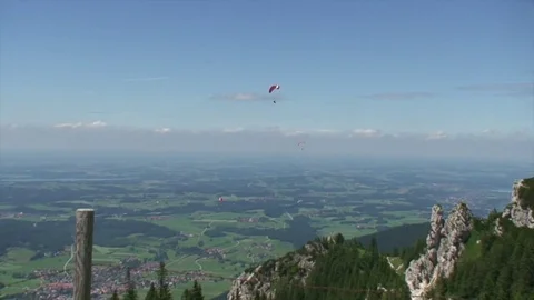 Hang gliders soar over a mountain valley in Bavaria, Germany Stock-Footage 77821414