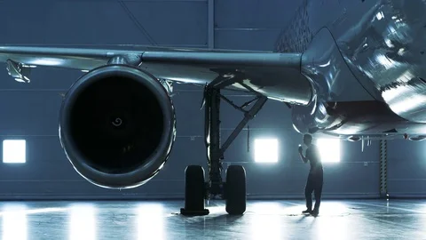 In a Hangar Aircraft Maintenance Engineer/ Technician/ Mechanic Inspects Plane Stock Footage 77260367