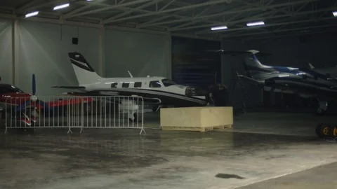 Hangar with three propeller airplanes parked. Mechanics repair airplanes engine Stock Footage 122085656