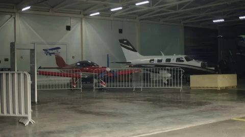 Hangar with two propeller airplanes parked. Mechanics repair airplanes engine Video stock 122085673