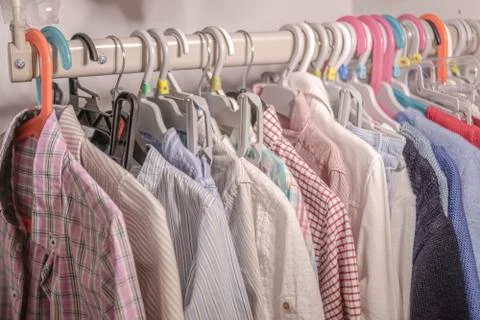 Hangers with children's clothes hanging on a stand in a closet Stock Photos