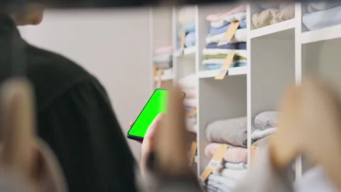 Hangers, Customer shopping Relaxed Looking at the green screen of the phone Stock Footage 242534407