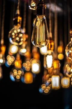 Hanging array of many incandescent light bulbs Stock Photos