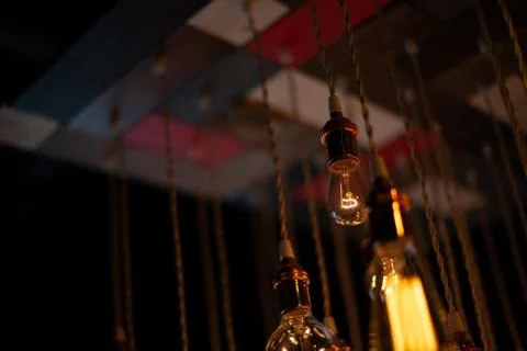 Hanging array of many incandescent light bulbs Stock Photos